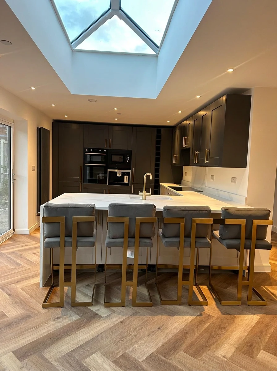Completed kitchen with roof lantern, dark cabinetry and island seating